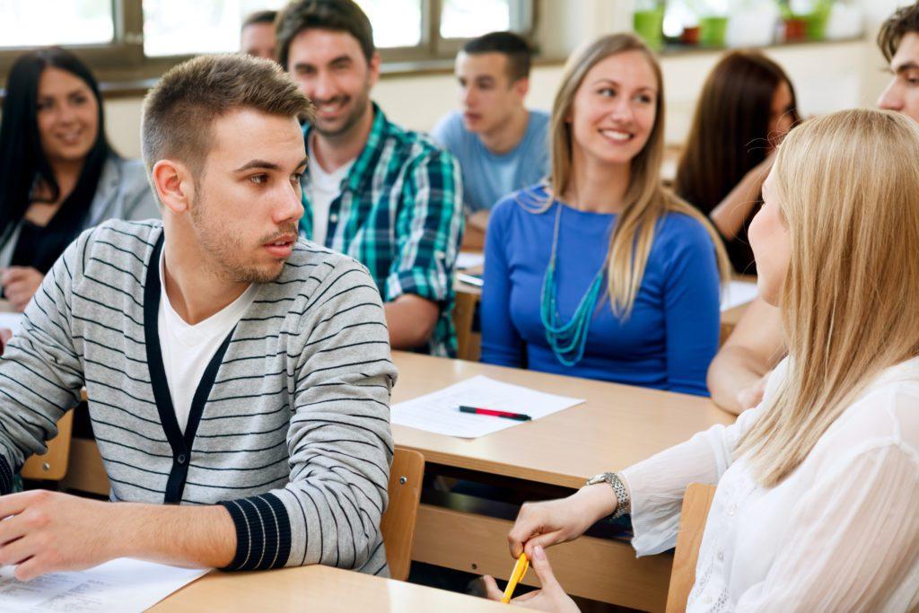 College students talking during class in a classroom